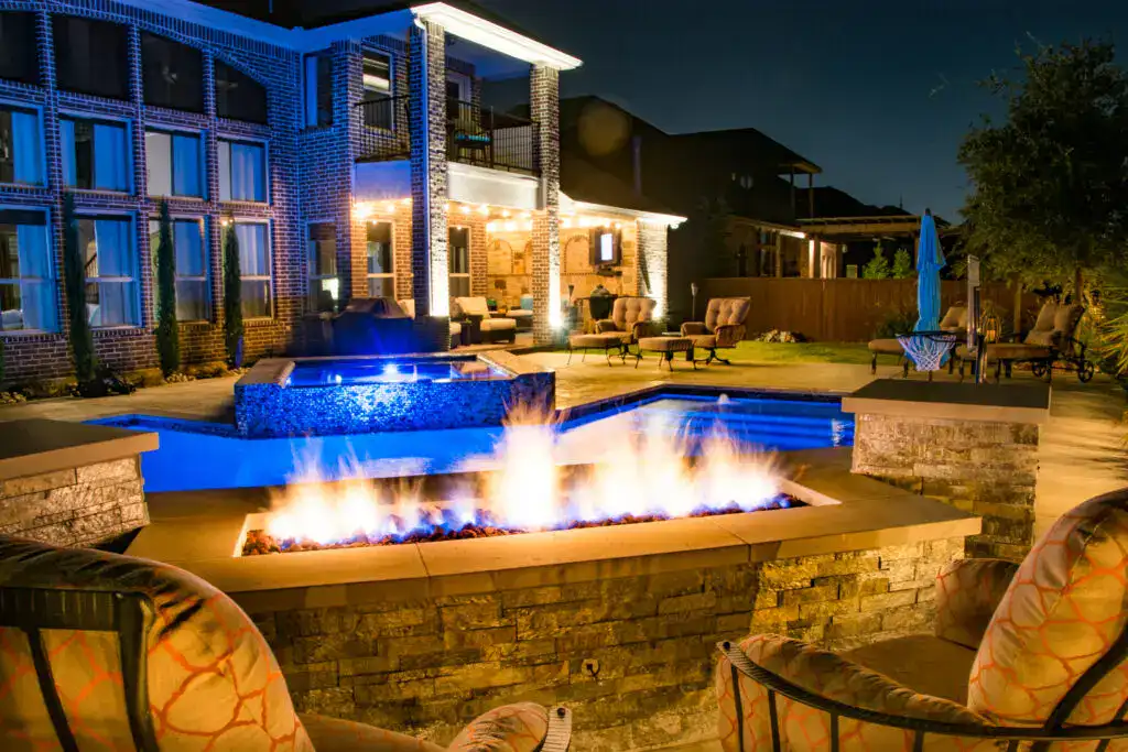Beautiful backyard pool with fire pit, lighting, and outdoor seating for relaxing evenings.