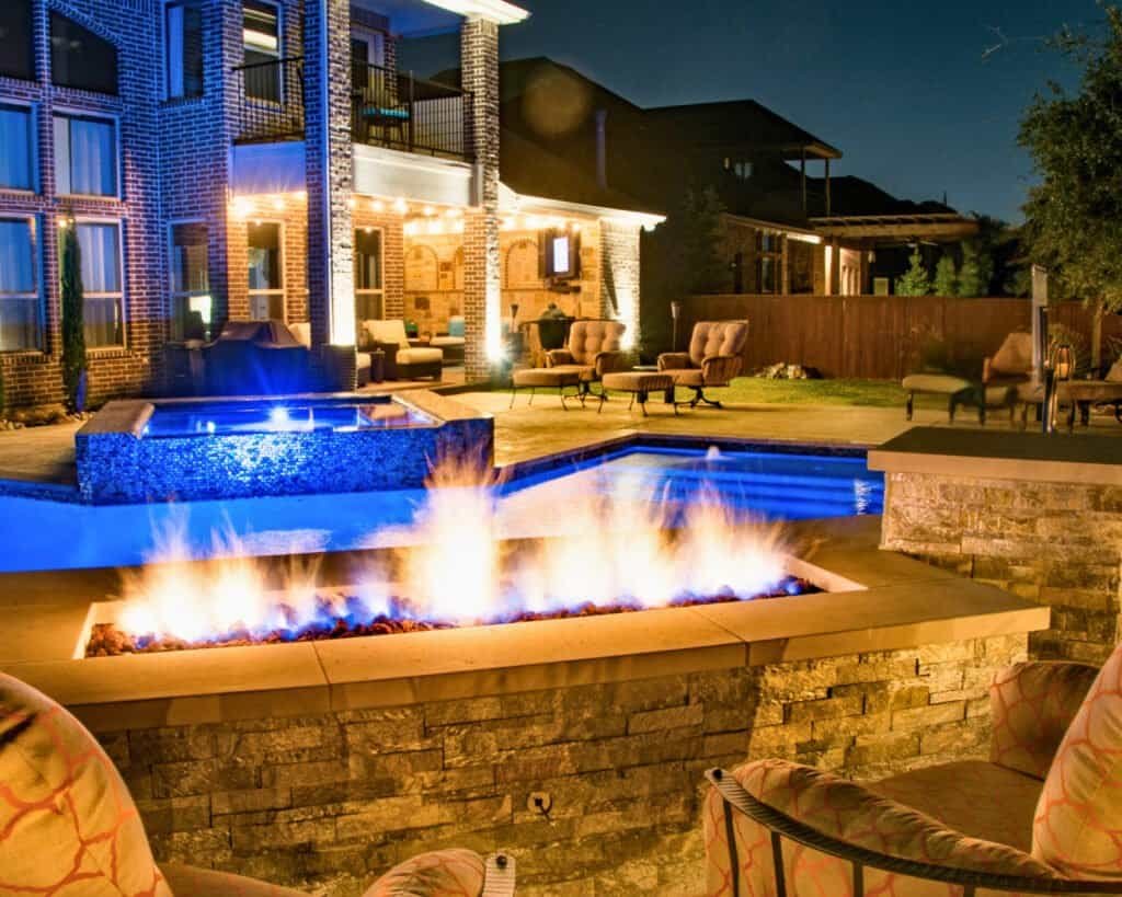 Richly textured pool with built-in fire features and outdoor seating, designed for durability and aesthetics.