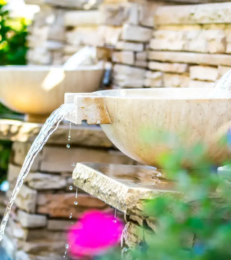 Elegant fountain features for backyard pools with professional plastering services.